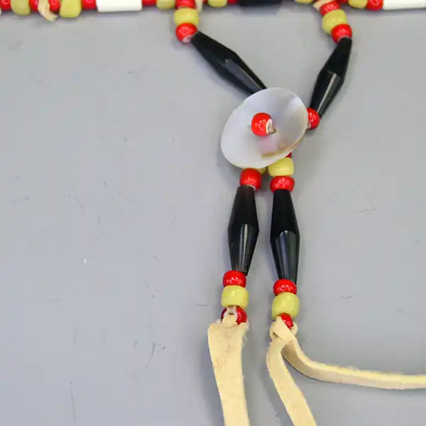 Choker- Greasy Yellow & Red this two-row choker features buffalo hairpipe, bone tube beads, shell conchos, and vibrant red and yellow beadwork.