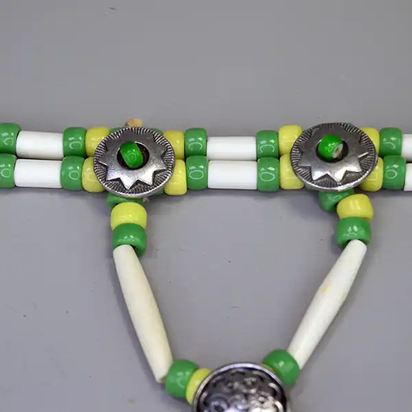 Handcrafted bone hairpipe Choker- Green & Yellow Crow beads, white-center pony beads, deerskin leather. approx. 15 inches. One of a Kind. Pictured here is the two buttons with the white center green pony beads.
