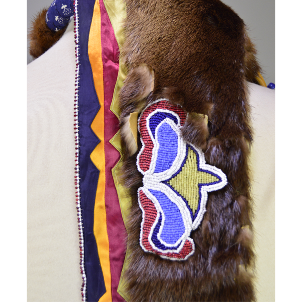 Necklace- Carved Bear Claw with cobalt blue glass beads and a removable ribbon work drop featuring beadwork, silver brooches, and otter fur. One of a Kind. The beaded design on the drop.