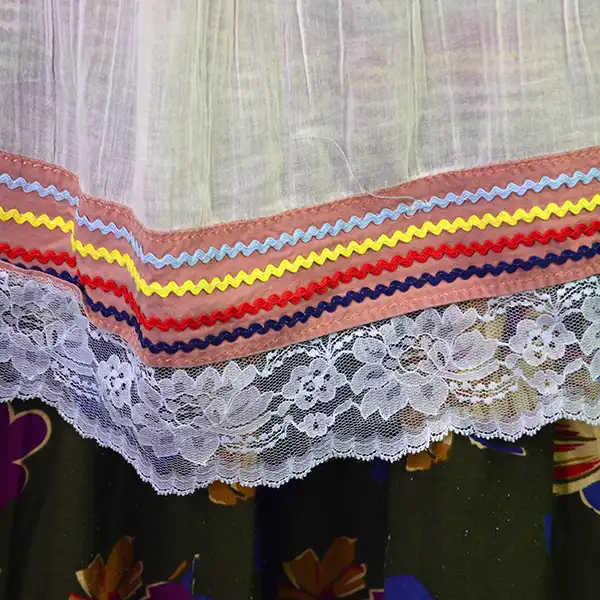 Vintage Skirt & Blouse- Seminole set with patchwork and geometric banding, rickrack trim, and classic strip‑piecing. One of a Kind. The bottom of the blouse and the light blue lace.
