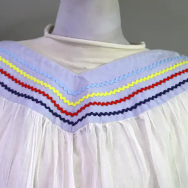 Vintage Skirt & Blouse- Seminole set with patchwork and geometric banding, rickrack trim, and classic strip‑piecing. One of a Kind The v neck of the blouse with the Ric rack design.
