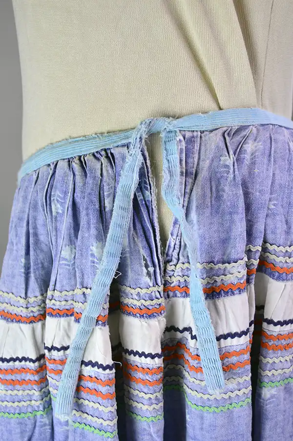 Vintage calico Seminole‑style patchwork skirt with multicolor rickrack, vibrant piecework, and traditional craftsmanship; shows gentle wear. One of a kind. The ties are a little frayed.